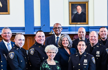 Hon. Norman St. George poses with court officers in a court house