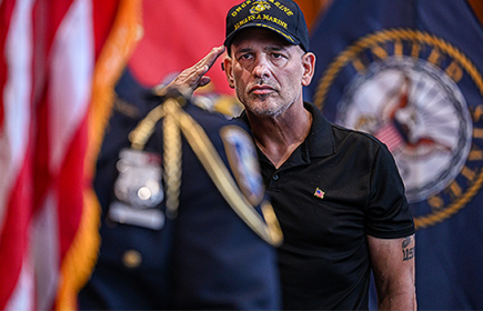 A veteran salutes in a court house ceremony