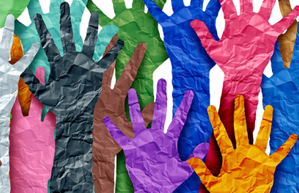 Photo of brightly colored paper hands reaching up 