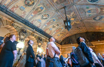 Photo of a group of people looking up at an intricate mosaic tiled ceiling