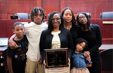 A group of youngsters and an adult in a courtroom