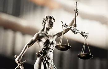 Photo of Lady Justice with law books in the background